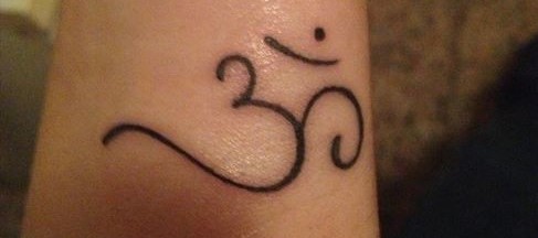 Tatuaje del símbolo de Om ॐ - Logia Tattoo Barcelona