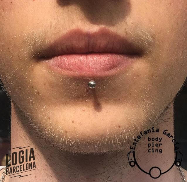 Detalhe de um piercing labret na boca de uma mulher sorridente